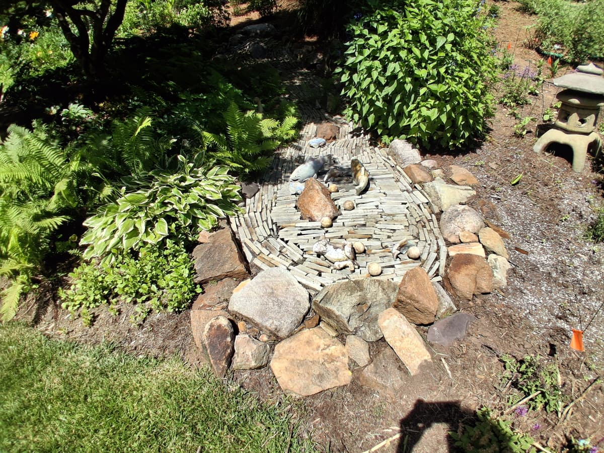 Stone water feature and surrounding landscape bed